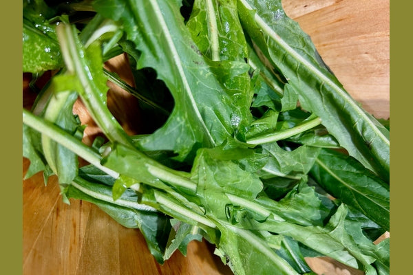 Dandelion greens on a wooden plank