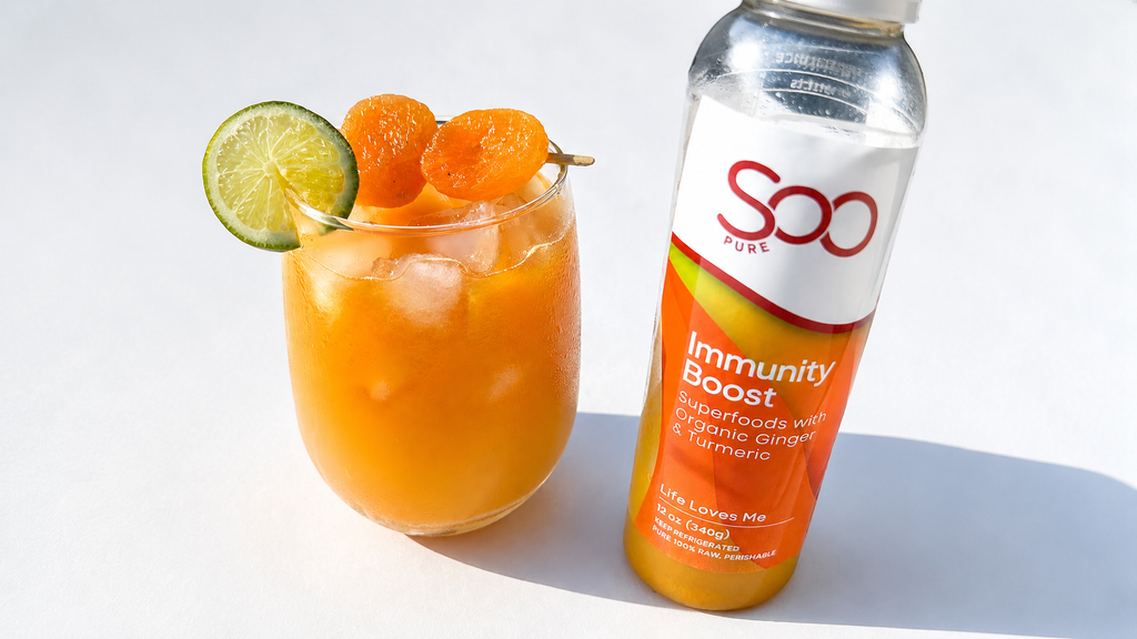 Glass of Immunity Boost Mocktail with garnishes next to a bottle of SoGo Pure Immunity Boost on a white background