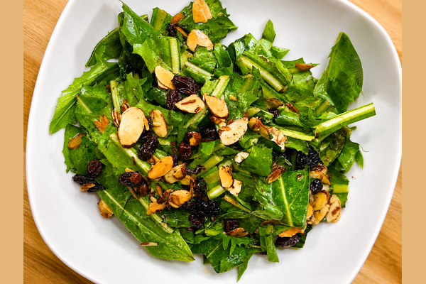 Dandelion salad with slicked almonds, raisins in a hot oil dressing