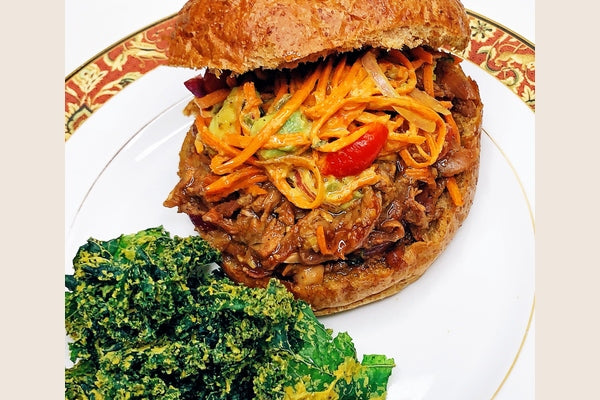 BBQ Jackfruit Sandwich with Creamy Carrot Slaw and kale chips on a plate. yum!