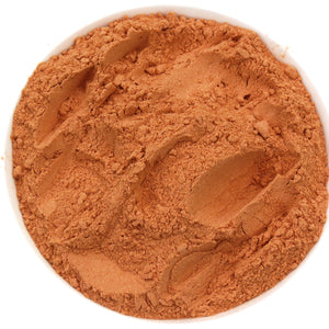 A white bowl of SoGo Pure Maca Mocha Me powder, a mix of cacao, maca, and astragalus