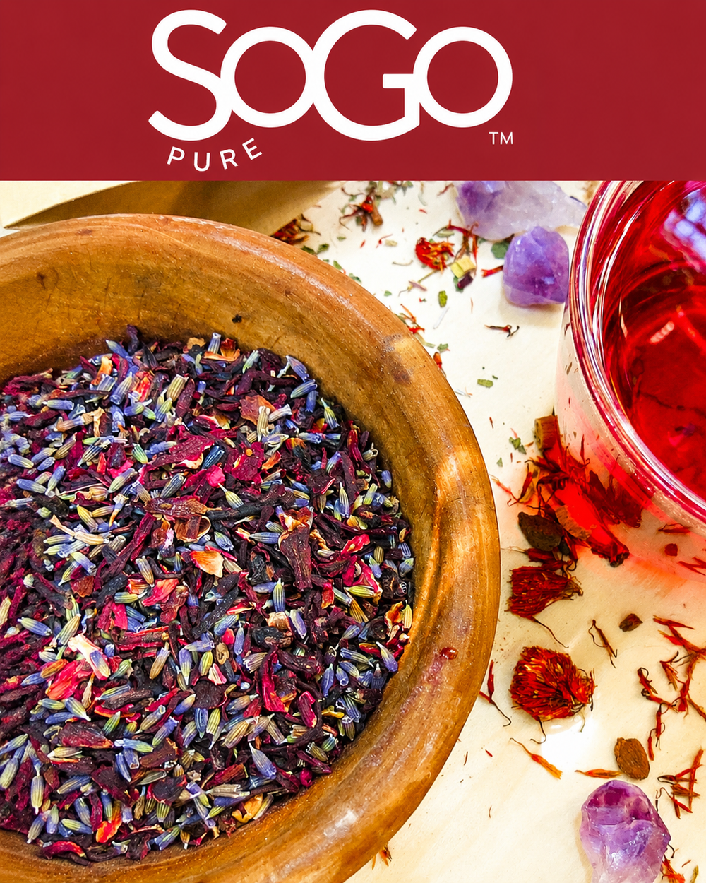Colorful dried herbs in a wooden bowl with a glass of tea and SOGO Pure logo.