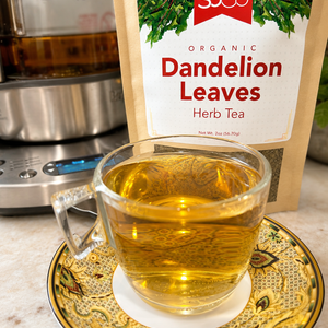 SoGo Pure Organic Dandelion Leaves, herbal tea on the counter with a cup of tea in front and the tea pot behind the bag.  