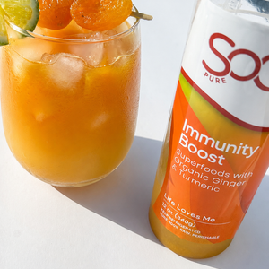 SoGo Pure Immunity Boost juice bottle beside the juice mocktail with lime and apricot garnish, with  ice on a bright white background.