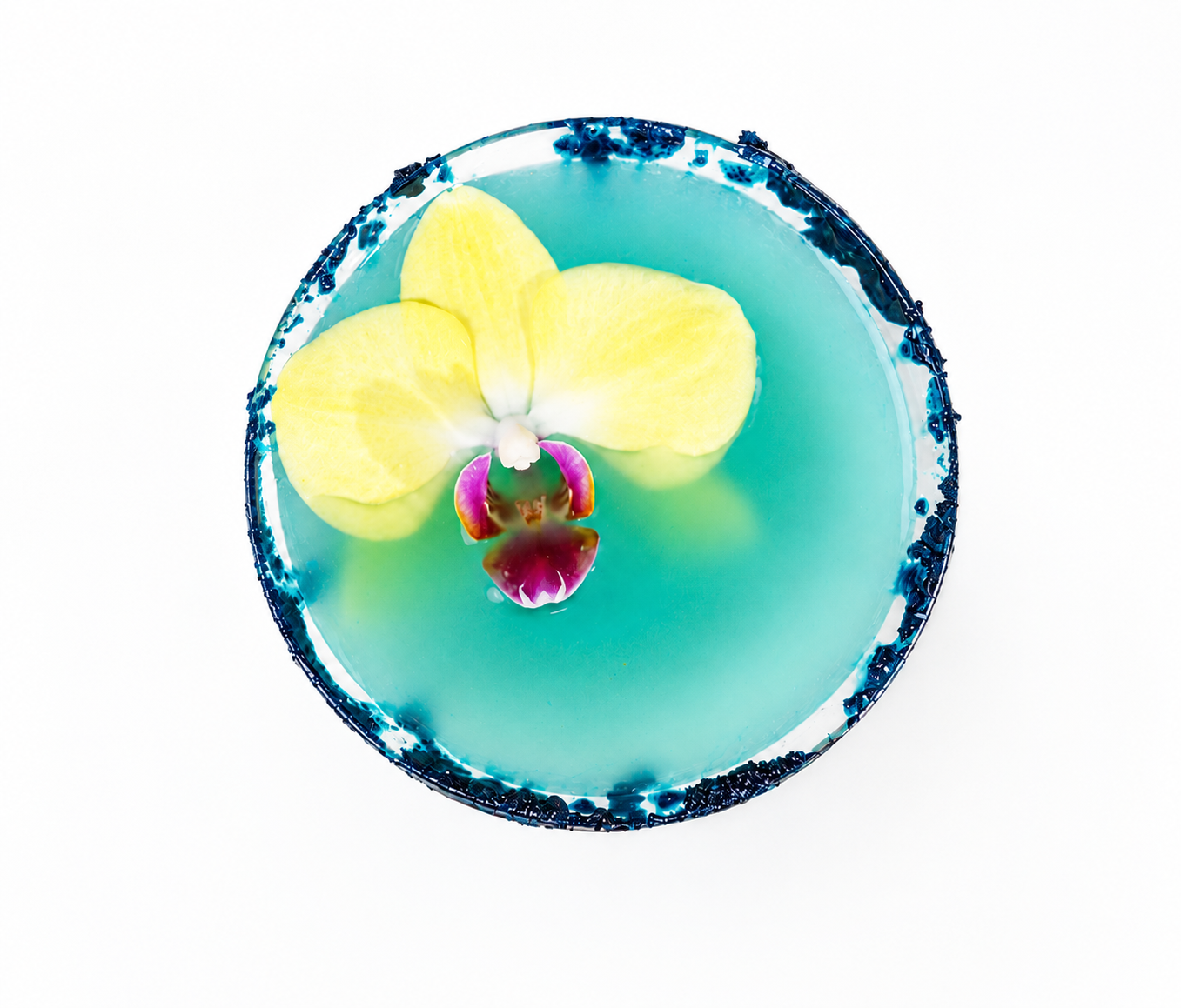 SoGo Pure Blu Lemonade mocktail with a yellow dendrobium orchid floating in the lemonade. The glass rim is coated in blue spirulina sugar. 